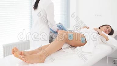 美容店里一个身材苗条的女人的腿和臀部受到肌刺激。